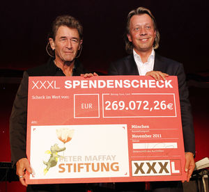 Helmuth Götz übergibt den XXXL Spendenscheck an Peter Maffay.